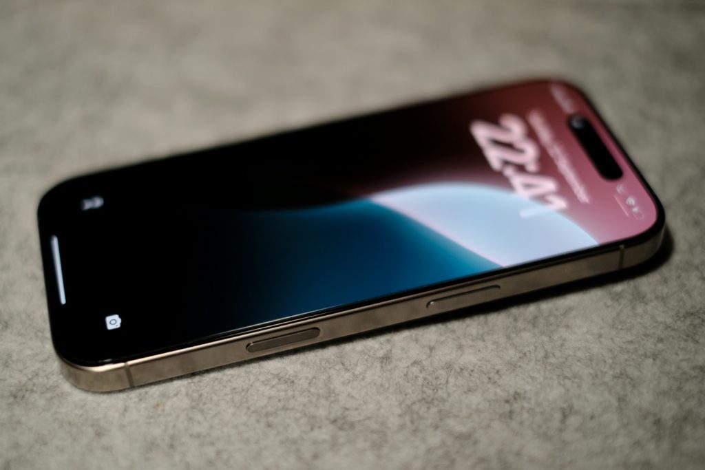 Jak iPhone 16, Plus, Pro i Pro Max radzą sobie z wodoszczelnością – klasa IP68 i testy A close up of a cell phone on a table