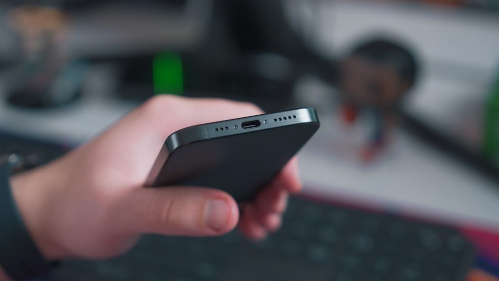 iPhone 15 – Plus, Pro i Pro Max: jak radzą sobie z wodoszczelnością i wodoodpornością? a close up of a person holding a cell phone