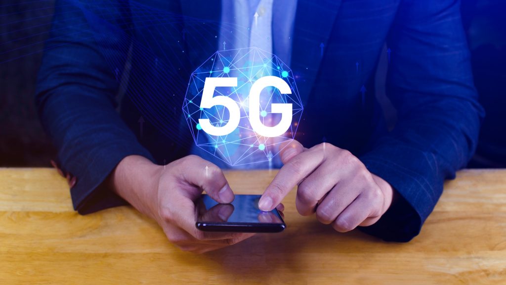 Biznes wykorzystujący smartfon z holograficzną koncepcją sieci 5G cyfrowy globus z połączonymi symbolami 5G Technologia 5G w nowoczesnej transformacji cyfrowej biznesu i komunikacji
