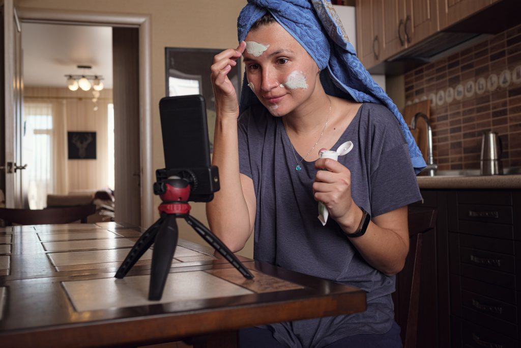 Kobieta siedzi w kuchni i robi maskę z zielonej gliny